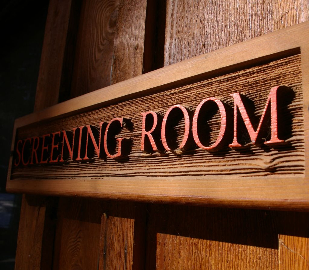 Rustic sign with red lettering at the front of the Screening Room.